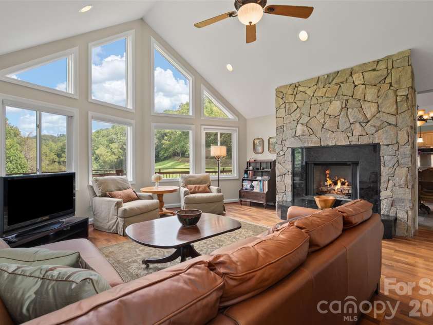 174 Marina Cove, Waynesville, NC 28785.  MLS# CAR4425258, YatesRealty ID 51963. Dramatic vaulted great room with soaring windows, hardwood flooring and impressive stone fireplace.