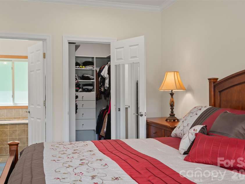 174 Marina Cove, Waynesville, NC 28785.  MLS# CAR4425258, YatesRealty ID 51963. Spacious primary suite with a large walk-in closet with custom shelving.