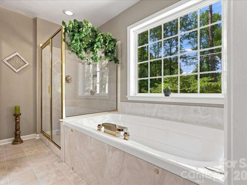 95 Scalybark Trail, Concord, NC 28027.  MLS# CAR4422844, YatesRealty ID 51966. Beautiful bath with walk in shower and soaking tub