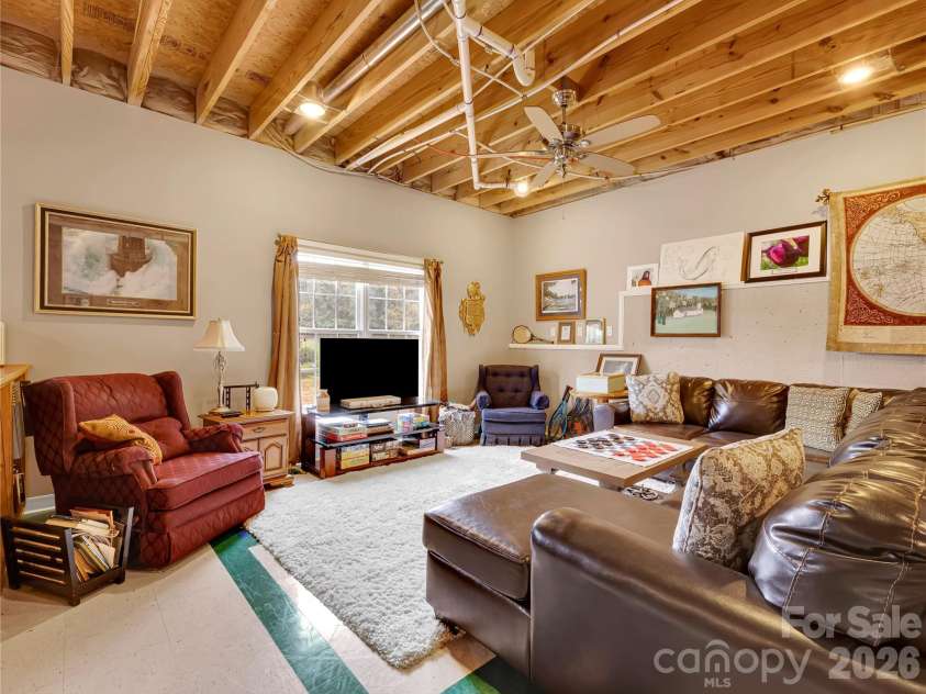 27 & 56 Troy Lane, Tryon, NC 28782.  MLS# CAR4426480, YatesRealty ID 52041. Cozy television room on this lower level will be a favorite destination!