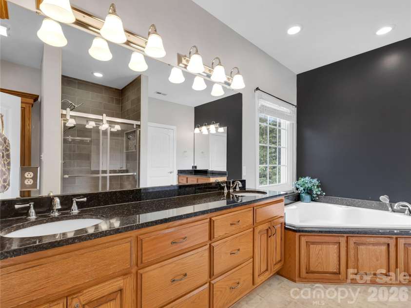 27 & 56 Troy Lane, Tryon, NC 28782.  MLS# CAR4426480, YatesRealty ID 52041. Primary bath with tons of counter space, second vanity, tiled shower and soaking tub.