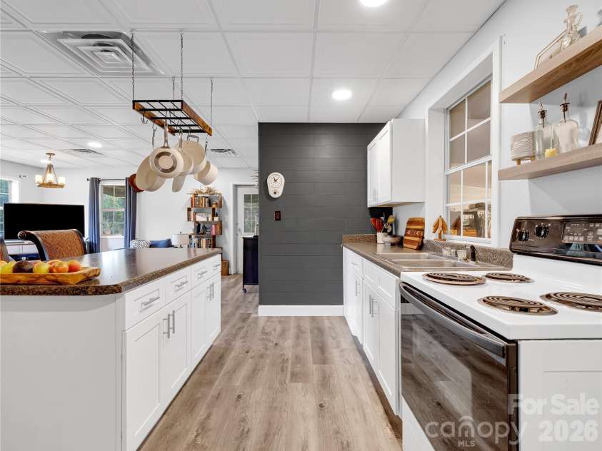 27 & 56 Troy Lane, Tryon, NC 28782.  MLS# CAR4426480, YatesRealty ID 52041. This compact kitchen is designed well and this home is currently a full time residence for three people.