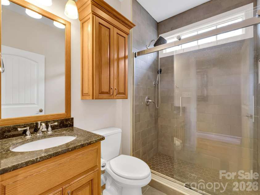 27 & 56 Troy Lane, Tryon, NC 28782.  MLS# CAR4426480, YatesRealty ID 52041. This full bath with a large tiled shower is located on the main floor. There is also a convenient half bath for guests on this level.