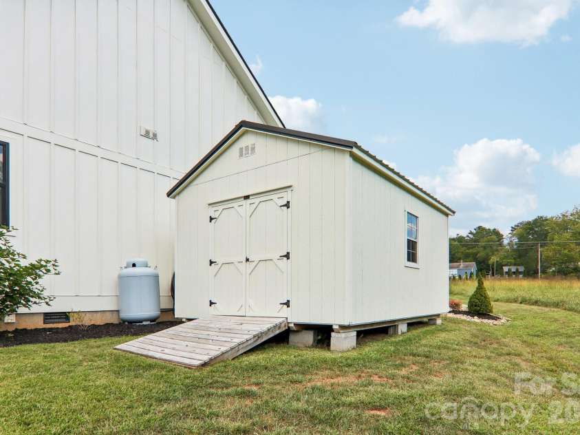 107 New Pinner Place, Arden, NC 28704.  MLS# CAR4426585, YatesRealty ID 52049. Shed on the side of Garage area