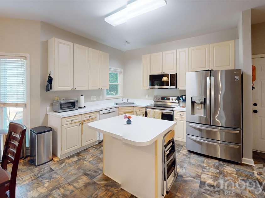 1606 Thornblade Ridge Drive, Matthews, NC 28105.  MLS# CAR4424953, YatesRealty ID 52073. Kitchen island provides extra counter space for kitchen prep or to grab a quick snack