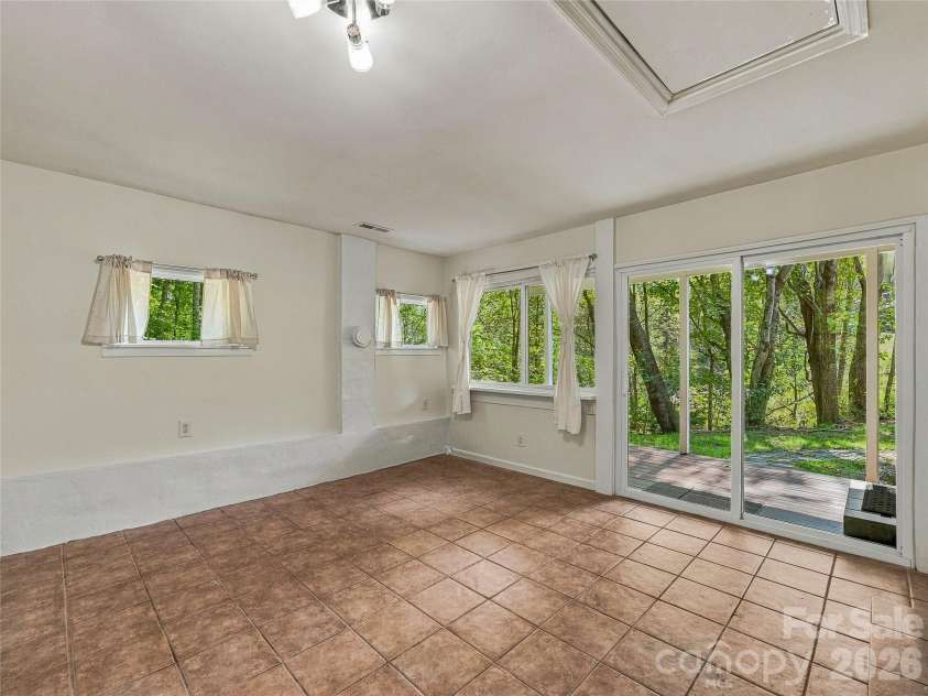 65 Passional Way, Burnsville, NC 28714.  MLS# CAR4427179, YatesRealty ID 52526. Tiled sunroom off kitchen
