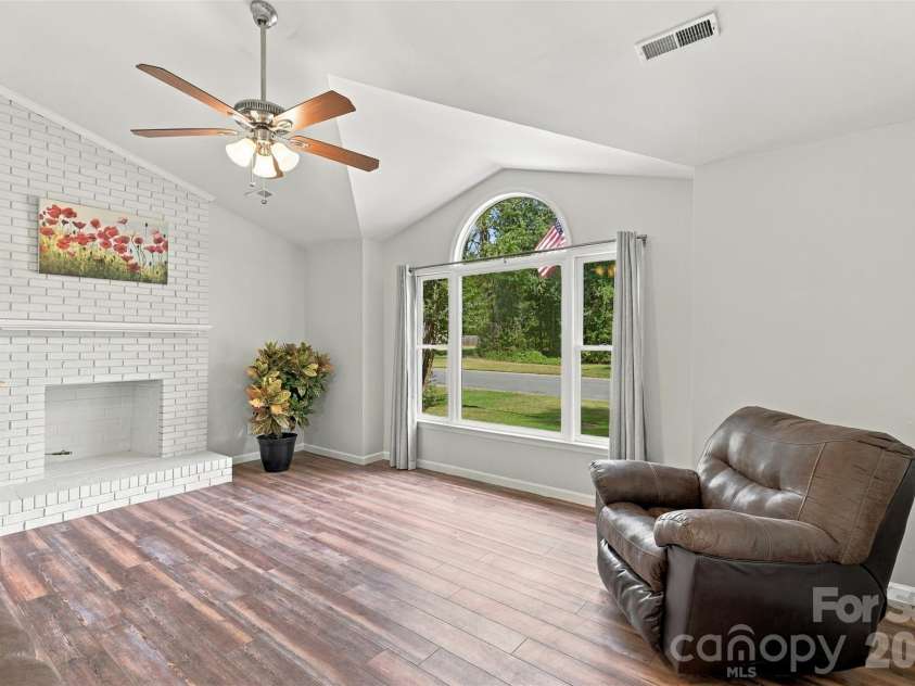 3000 Faircroft Way, Monroe, NC 28110.  MLS# CAR4427543, YatesRealty ID 52533. Cozy living room w/ oversized window, centered around a brick fireplace