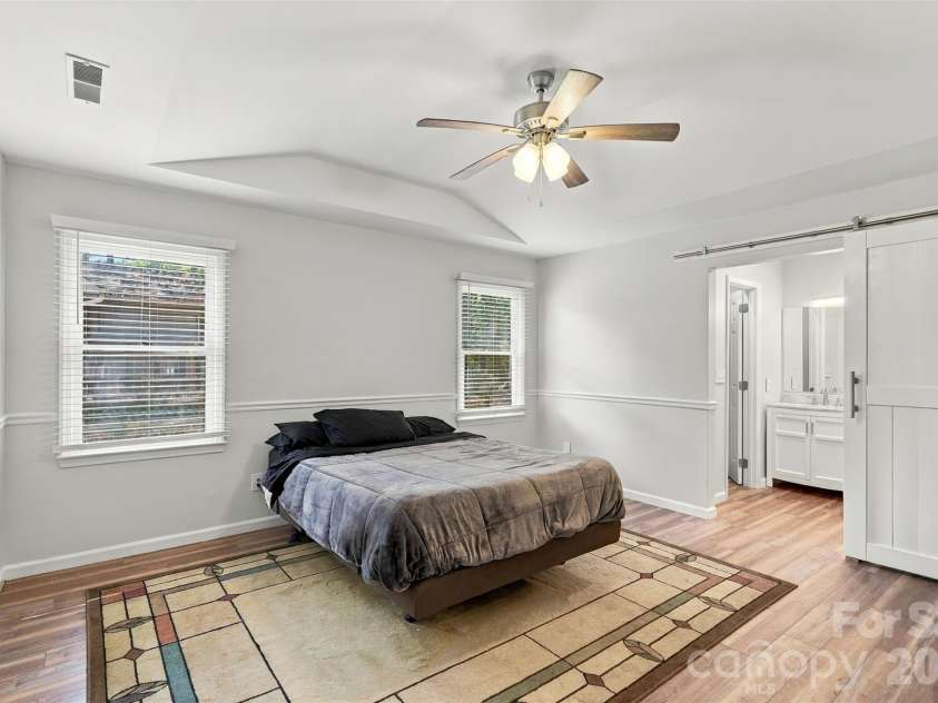 3000 Faircroft Way, Monroe, NC 28110.  MLS# CAR4427543, YatesRealty ID 52533. Primary bedroom featuring a tray ceiling, ensuite full bath (with a neat sliding door as a divider), and a WIC