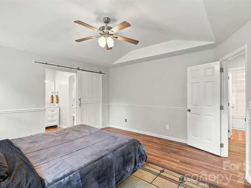 3000 Faircroft Way, Monroe, NC 28110.  MLS# CAR4427543, YatesRealty ID 52533. Primary bedroom featuring a tray ceiling, ensuite full bath (with a neat sliding door as a divider), and a WIC