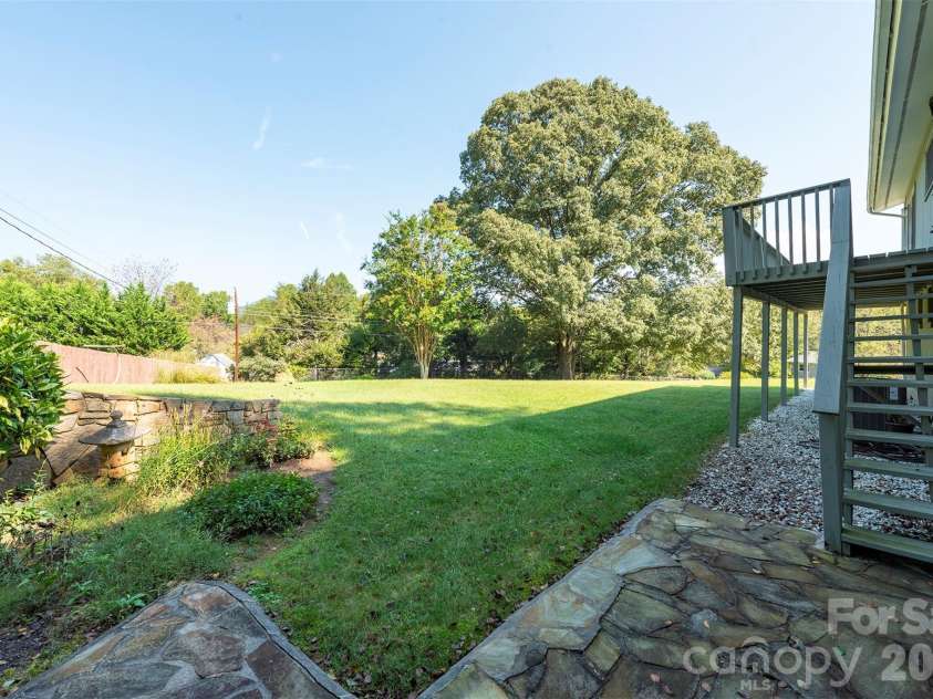 127 College Circle, Swannanoa, NC 28778.  MLS# CAR4427251, YatesRealty ID 52594. Backyard stone patio and stairway to deck