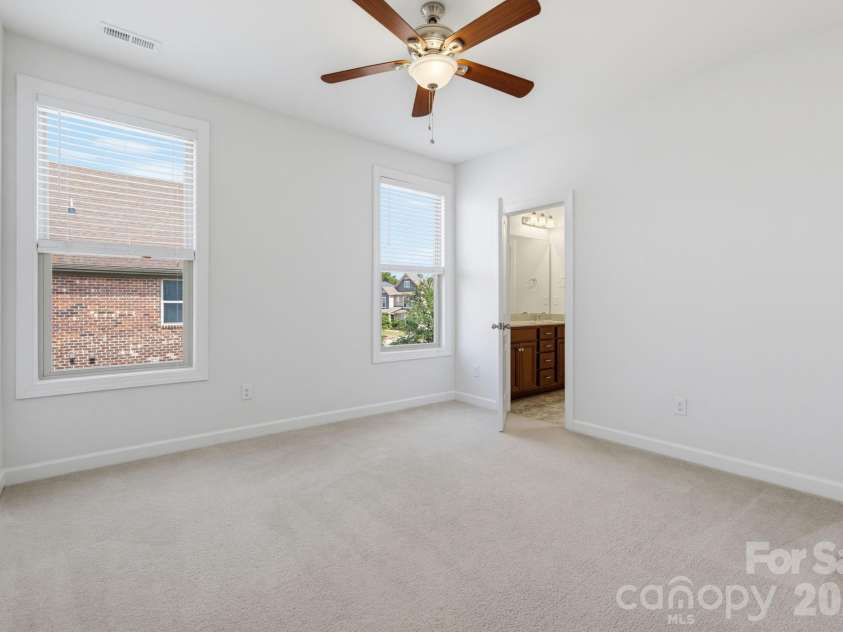 8315 Breton Way, Harrisburg, NC 28075.  MLS# CAR4426522, YatesRealty ID 52653. Two generous windows fill this second-level bedroom with natural light, while its comfortable footprint and direct bathroom access create a bright, functional space that can grow and change with the family.