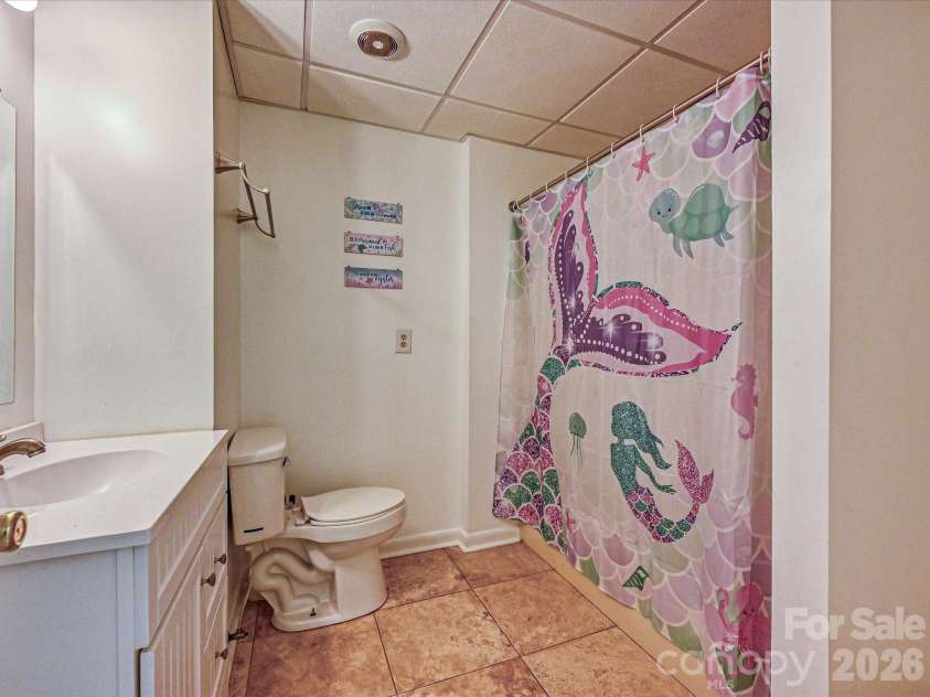 3017 Vernell Lane, Shelby, NC 28150.  MLS# CAR4425376, YatesRealty ID 52670. Lower-level Full Bath featuring a spacious vanity, tub/shower combination, and tile flooring for added convenience.