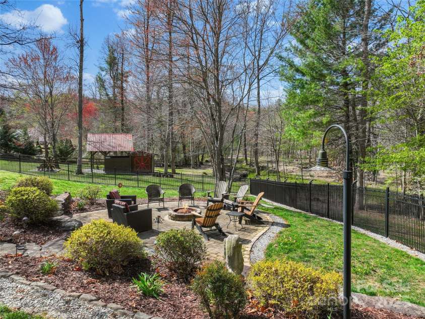 79 Pattys Chapel Road, Fletcher, NC 28732.  MLS# CAR4239671, YatesRealty ID 5295. Alternate view of firepit area, back yard and into the woods.