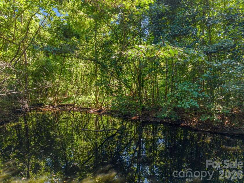 145 Stone Hedge Lane, Tryon, NC 28782.  MLS# CAR4428268, YatesRealty ID 53072. Pond is visible but not easily accessed