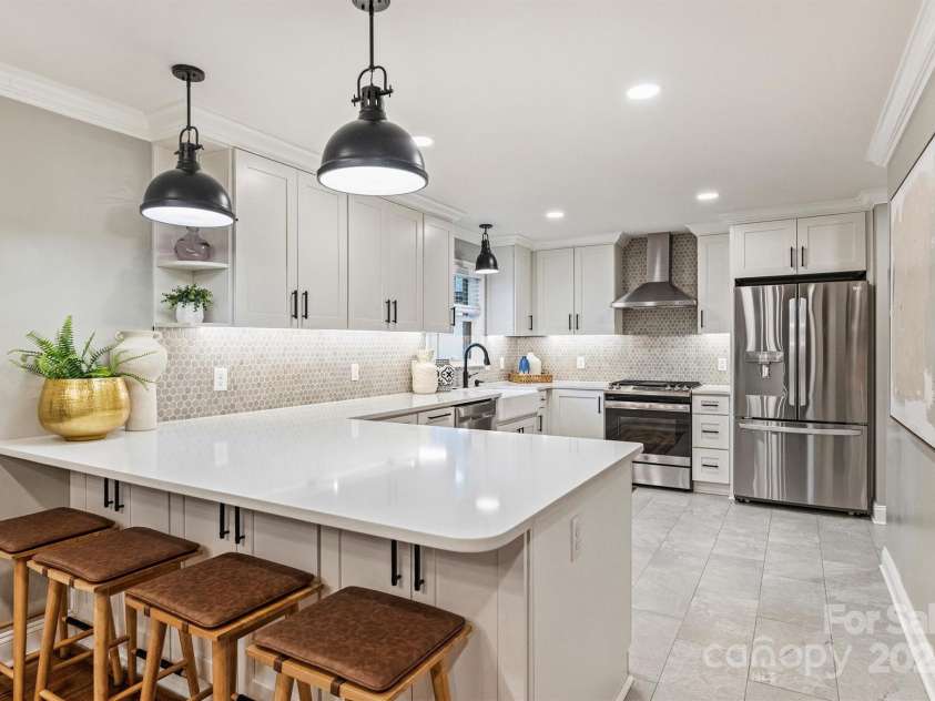 500 Lansdowne Road, Charlotte, NC 28270.  MLS# CAR4240388, YatesRealty ID 5327. The beautifully appointed kitchen is equipped with quartz countertops, new cabinetry, a gas range with hood, and stainless steel appliances.