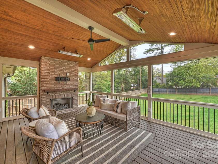 500 Lansdowne Road, Charlotte, NC 28270.  MLS# CAR4240388, YatesRealty ID 5327. The covered deck featuring a gas fireplace, vaulted ceilings, and space heaters offers an extended living space for year-round comfort.