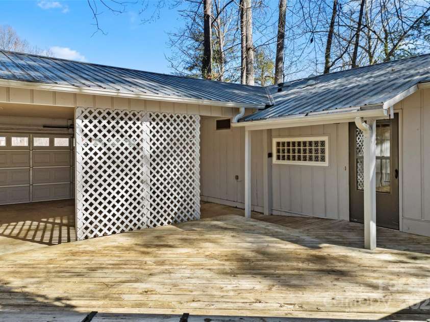 550 Kinross Drive, Flat Rock, NC 28731.  MLS# CAR4215035, YatesRealty ID 535. Front door to cottage and carport