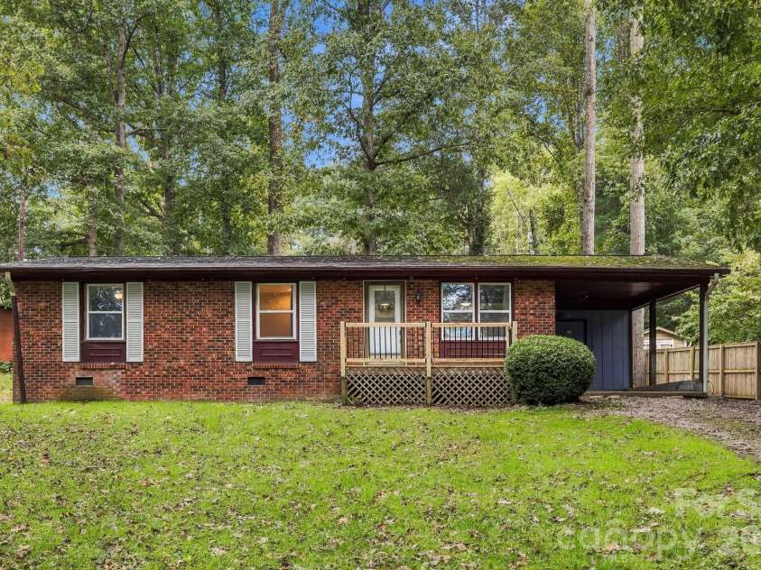 36 Medlin Lane, Flat Rock, NC 28731.  MLS# CAR4428597, YatesRealty ID 53594. Attractive single-level brick facade home with a spacious front yard, mature shade trees, and convenient covered parking.