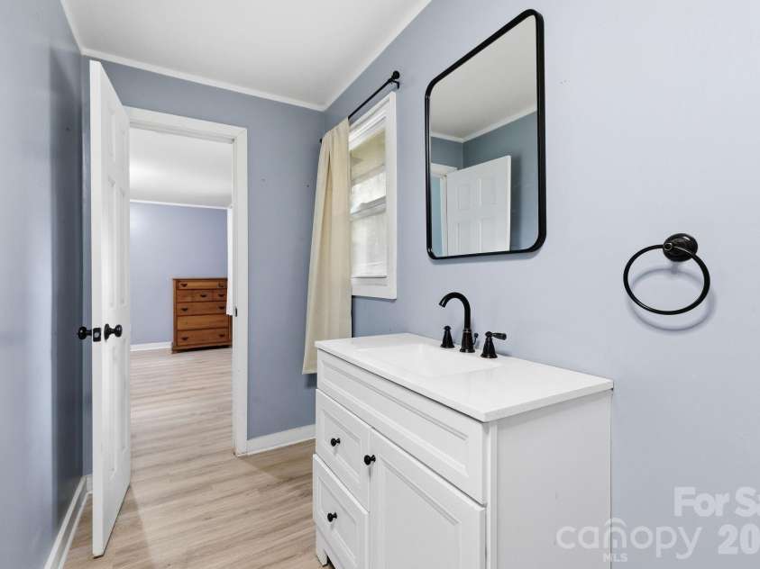 36 Medlin Lane, Flat Rock, NC 28731.  MLS# CAR4428597, YatesRealty ID 53594. Bright primary bath with updated vanity, modern fixtures, and natural light.