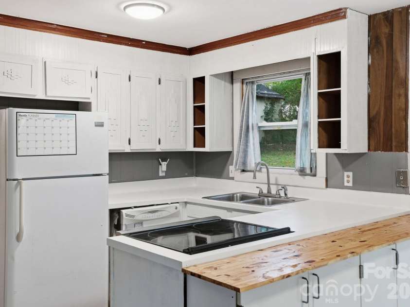 36 Medlin Lane, Flat Rock, NC 28731.  MLS# CAR4428597, YatesRealty ID 53594. Kitchen features white cabinetry, generous counter space, and a peninsula with additional workspace and storage.