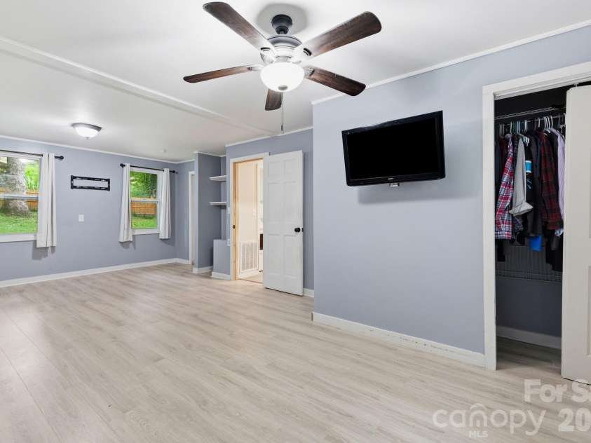 36 Medlin Lane, Flat Rock, NC 28731.  MLS# CAR4428597, YatesRealty ID 53594. Primary bedroom features multiple windows, ceiling fan, and generous closet space.