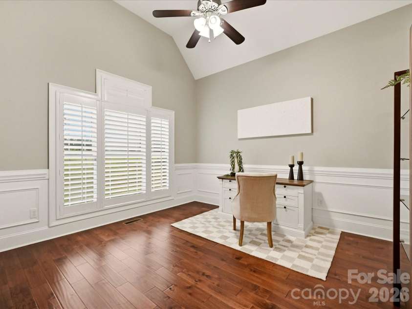 3167 James Plantation Drive, Denver, NC 28037.  MLS# CAR4429243, YatesRealty ID 53666. A bright home office features vaulted ceilings, gorgeous flooring, elegant wainscoting, plantation shutters, and generous space for a comfortable work-from-home setup.