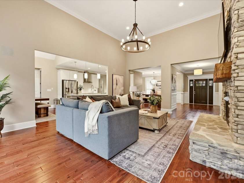 3167 James Plantation Drive, Denver, NC 28037.  MLS# CAR4429243, YatesRealty ID 53666. A spacious Great Room features soaring ceilings, beautiful flooring, a dramatic stacked-stone fireplace, abundant natural light, and an open connection to the kitchen and dining areas.