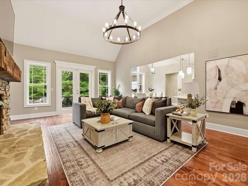 3167 James Plantation Drive, Denver, NC 28037.  MLS# CAR4429243, YatesRealty ID 53666. A spacious Great Room features soaring ceilings, rich floors, a dramatic stacked-stone fireplace, abundant natural light, and an open connection to the kitchen and dining areas.