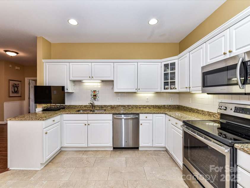 11406 Olde Turnbury Court, Charlotte, NC 28277.  MLS# CAR4233679, YatesRealty ID 5369. Tv on extendable arm remains...don't miss the upper glass display cabinet.