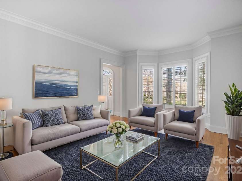 1131 Kings Drive, Charlotte, NC 28207.  MLS# CAR4235522, YatesRealty ID 5393. Greet your neighbors and guests in the Living Room with bay window and heavy moldings. (Staged virtually)
