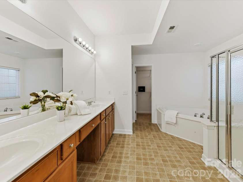 8128 Madrigal Court, Waxhaw, NC 28173.  MLS# CAR4429672, YatesRealty ID 53943. A spacious double vanity with makeup table is featured in the Primary bath.
