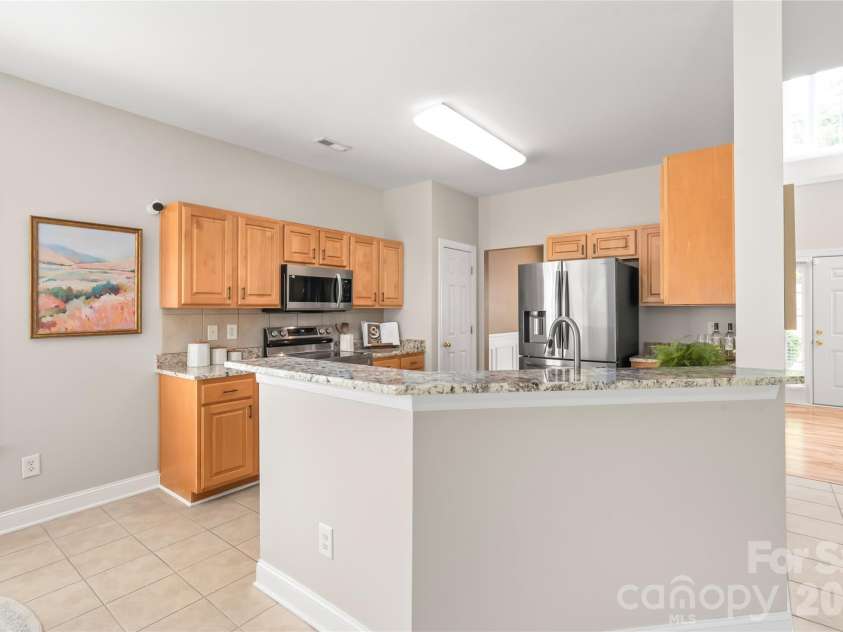 2008 Trace Creek Drive, Waxhaw, NC 28173.  MLS# CAR4428166, YatesRealty ID 53969. This chef-inspired kitchen shines with updated granite countertops, tile backsplash, sleek stainless steel appliances, and plenty of prep space for cooking.