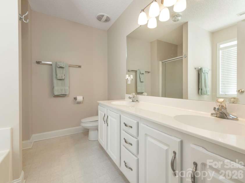 8415 Quail Hollow Drive, Harrisburg, NC 28075.  MLS# CAR4424111, YatesRealty ID 54022. Ensuite bathroom with double sink vanity and step-in shower