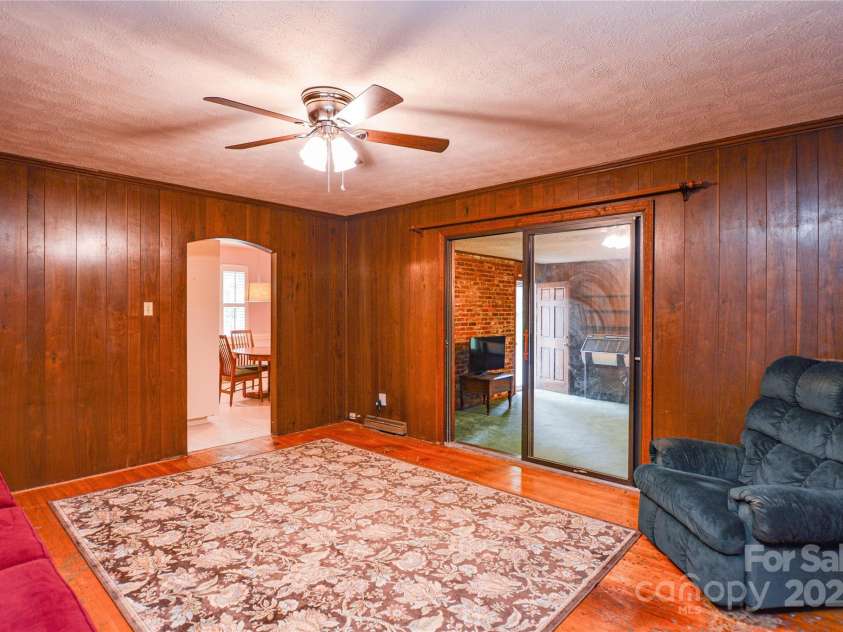 2429 Sugar Mill Road, Charlotte, NC 28210.  MLS# CAR4245721, YatesRealty ID 5405. Another view of the Family Room looking towards the kitchen and Recreation room showing the classic paneling, hardwood flooring, and ceiling fan.