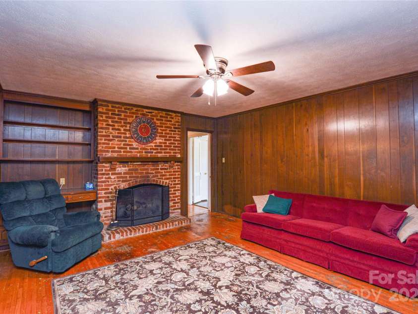 2429 Sugar Mill Road, Charlotte, NC 28210.  MLS# CAR4245721, YatesRealty ID 5405. Another view of the Family Room showing the Classic Brick Hearth, hardwoods, paneling, and ceiling fan.