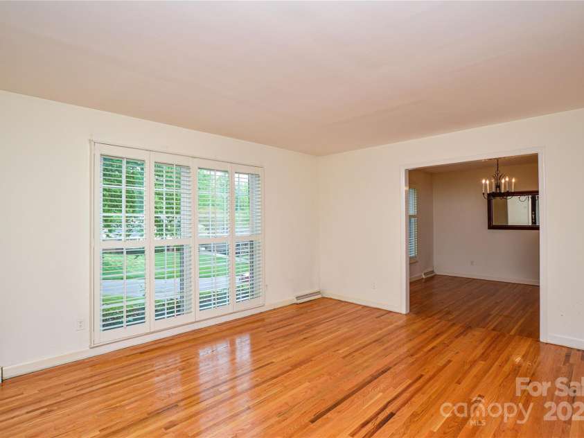 2429 Sugar Mill Road, Charlotte, NC 28210.  MLS# CAR4245721, YatesRealty ID 5405. Another view of the living room showing the custom plantation shutters and classic hardwood floors.