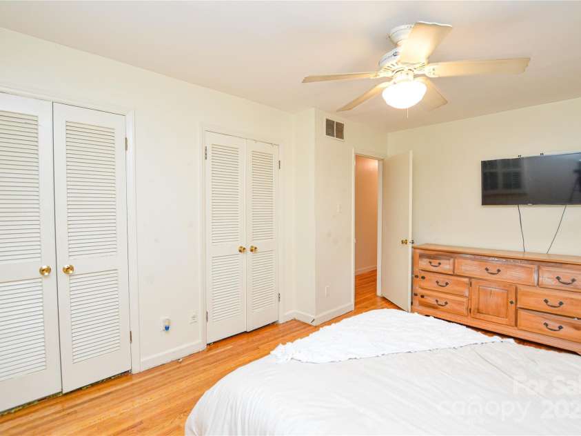 2429 Sugar Mill Road, Charlotte, NC 28210.  MLS# CAR4245721, YatesRealty ID 5405. Primary Bedroom showing DUAL closets, hardwood floors, and ceiling fan.