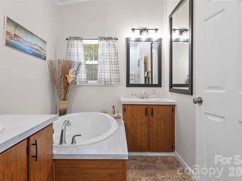183 Gobbler Circle, Horse Shoe, NC 28742.  MLS# CAR4430660, YatesRealty ID 54240. Primary bathroom with separate vanities, a soaking tub, and a separate shower.