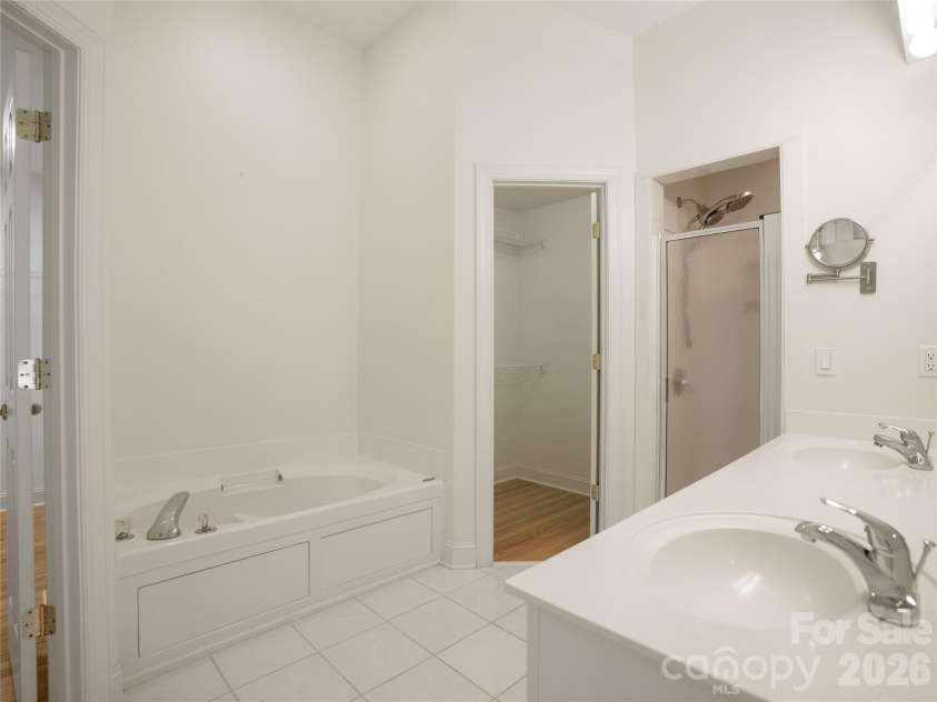 1011 Overhill Drive, Salisbury, NC 28144.  MLS# CAR4429292, YatesRealty ID 54283. Primary ensuite bathroom featuring a deep soaking jet-garden tub, dual-sink vanity, separate walk-in shower, tile flooring, and direct access to a dual walk-in closets
