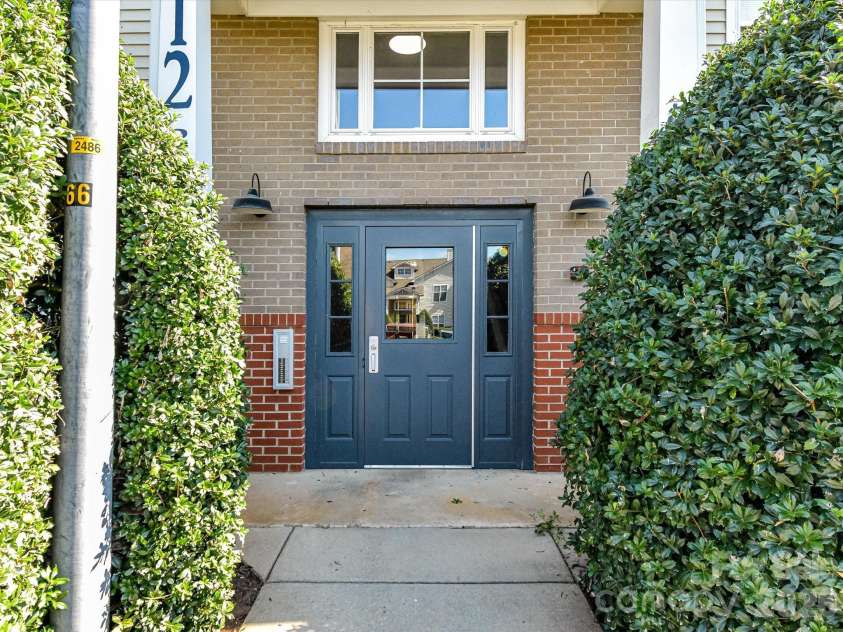 9031 Mcdowell Creek Court, Cornelius, NC 28031.  MLS# CAR4428404, YatesRealty ID 54302. Convenient rear building entrance featuring a covered entry, secure access, and well-maintained landscaping for easy everyday access to the condo.