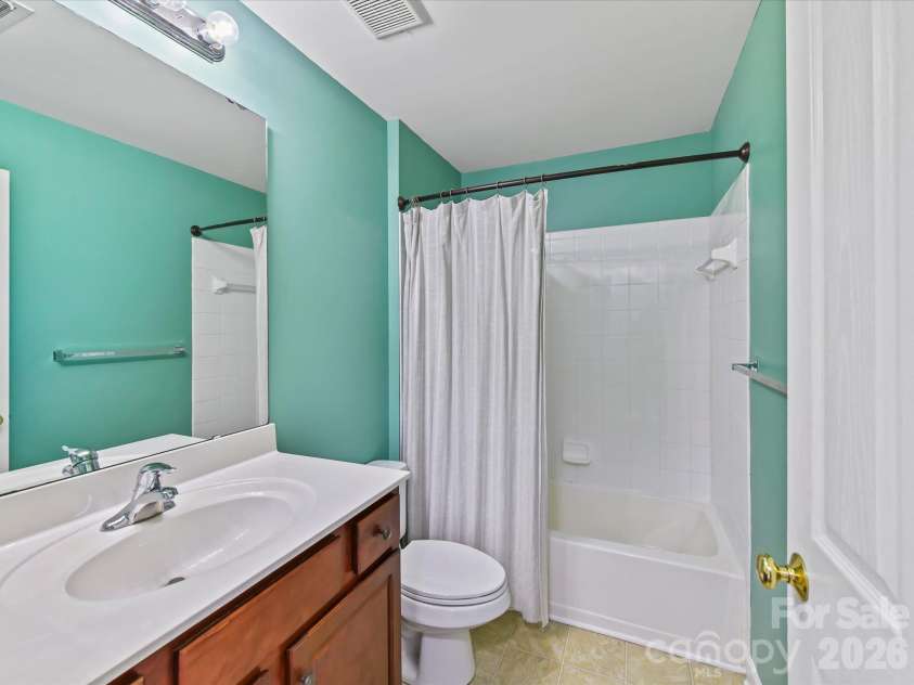 9031 Mcdowell Creek Court, Cornelius, NC 28031.  MLS# CAR4428404, YatesRealty ID 54302. Full bath featuring a spacious vanity, large mirror, tub/shower combination with tile surround, and a bright, functional layout.