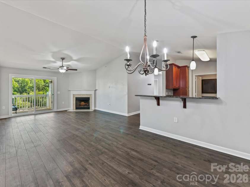 9031 Mcdowell Creek Court, Cornelius, NC 28031.  MLS# CAR4428404, YatesRealty ID 54302. Spacious dining area featuring LVP flooring, a vaulted ceiling, statement chandelier, and an open connection to the kitchen and family room for easy entertaining.