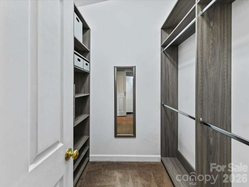 9031 Mcdowell Creek Court, Cornelius, NC 28031.  MLS# CAR4428404, YatesRealty ID 54302. Spacious primary walk-in closet featuring a custom organization system with built-in shelving, multiple hanging areas, and generous storage space.