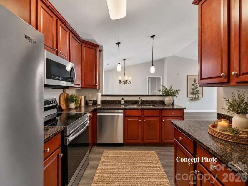 9031 Mcdowell Creek Court, Cornelius, NC 28031.  MLS# CAR4428404, YatesRealty ID 54302. Virtually staged Well-appointed kitchen featuring rich wood cabinetry, granite countertops, stainless steel appliances, ample storage, and a convenient breakfast bar overlooking the adjoining living and dining ar