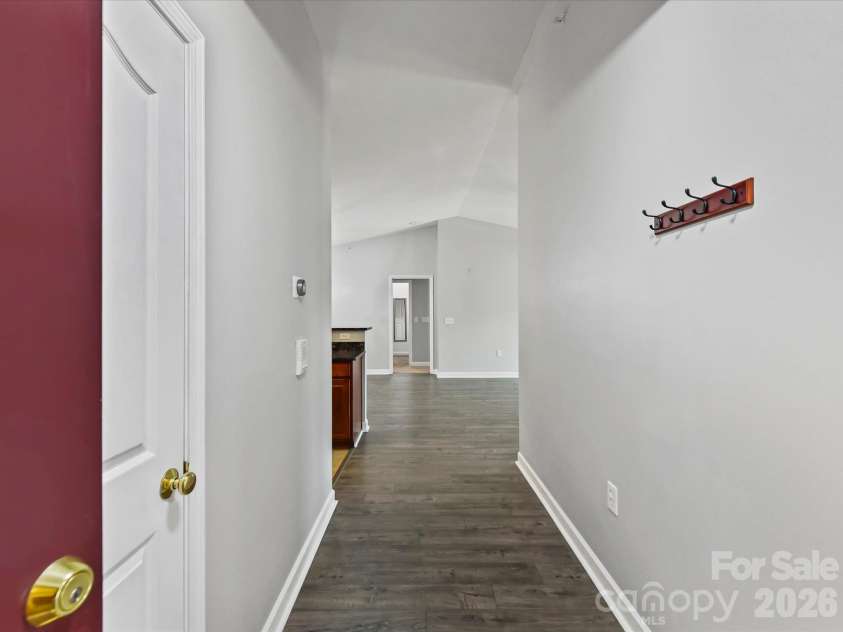 9031 Mcdowell Creek Court, Cornelius, NC 28031.  MLS# CAR4428404, YatesRealty ID 54302. Welcoming condo entryway featuring LVP flooring, neutral finishes, convenient wall hooks, and an open sightline into the main living areas.