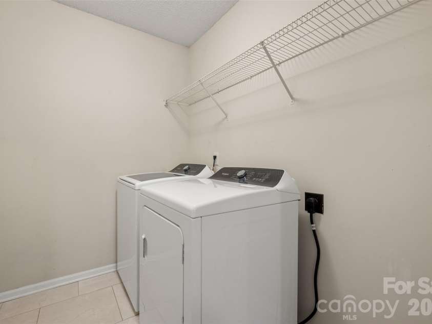 2738 Mill Valley Court, Matthews, NC 28105.  MLS# CAR4424420, YatesRealty ID 54340. Convenient upper-level dedicated laundry room equipped with washer/dryer hookups and built-in wire shelving for organized storage and easy laundry days.