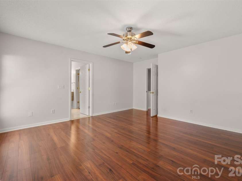 2738 Mill Valley Court, Matthews, NC 28105.  MLS# CAR4424420, YatesRealty ID 54340. Primary bedroom layout highlighting generous floor space, double closet doors for ample storage, and overhead ceiling fan.