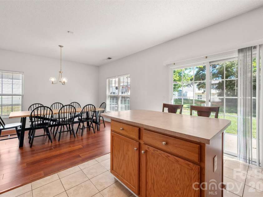 2738 Mill Valley Court, Matthews, NC 28105.  MLS# CAR4424420, YatesRealty ID 54340. Spacious kitchen island providing additional counter space and informal seating, with sliding glass doors leading out to the rear patio and yard.
