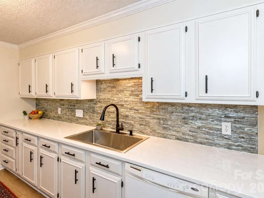 503 Crowfields Lane, Asheville, NC 28803.  MLS# CAR4429548, YatesRealty ID 54988. Freshly renovated kitchen with quartz counters, deep sink and sleek glass back splash