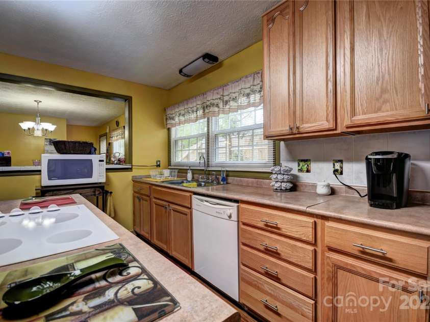 201 Acorn Lane, Clyde, NC 28721.  MLS# CAR4153632, YatesRealty ID 5499. Kitchen showing pass-through to the dining area